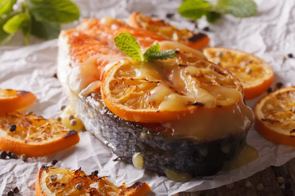 Juicy salmon steak baked with oranges macro on paper. horizontal — Stock Photo, Image