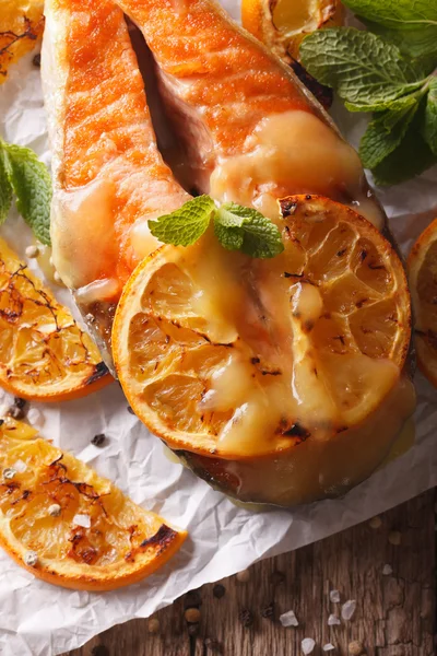 Filete de salmón al horno con naranjas de cerca. vista superior vertical, rus —  Fotos de Stock