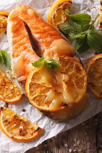 Salmón al horno con naranjas de cerca sobre la mesa. Parte superior vertical vi —  Fotos de Stock
