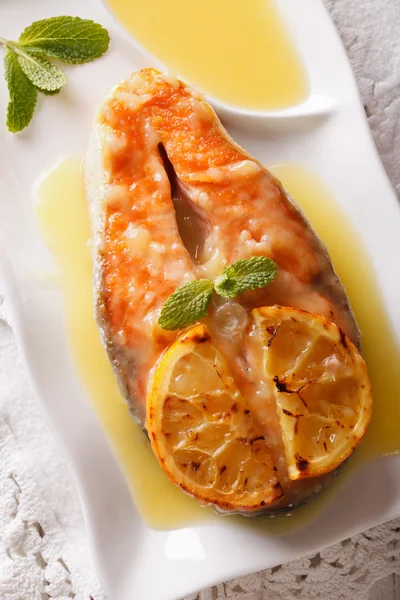 Baked salmon steak with orange on a plate closeup. Vertical top — Stock Photo, Image