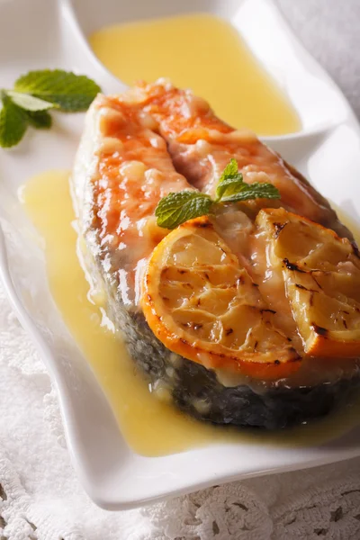 Baked salmon steak with orange sauce and mint close-up. Vertical — Stock Photo, Image