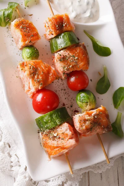 Grilled salmon on skewers close-up on a plate. vertical top view — Stock Photo, Image