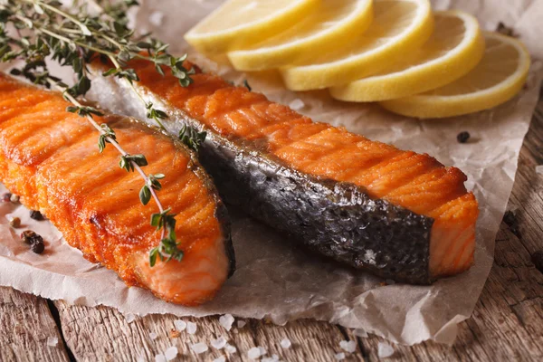 Grilled salmon with lemon and thyme on a paper close-up. Horizon — Stock Photo, Image
