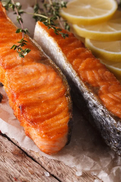 Delicious food: grilled salmon with lemon on the paper macro. ve — Stock Photo, Image