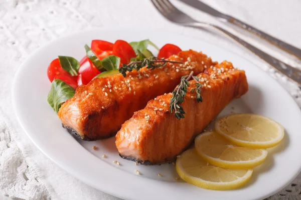 Grilled salmon with lemon and salad on the plate closeup. Horizo — Stock Photo, Image