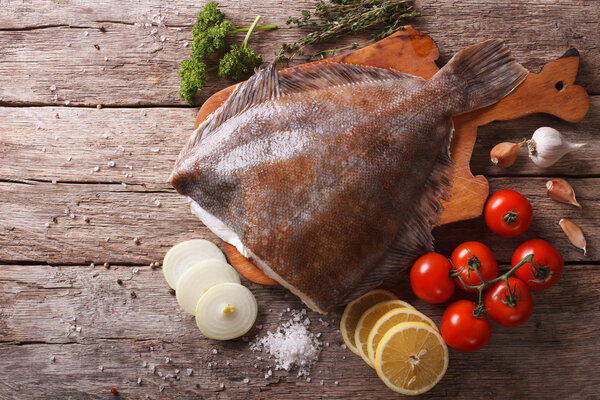 сырая камбала с ингредиентами на столе. Горизонтальный вид сверху
