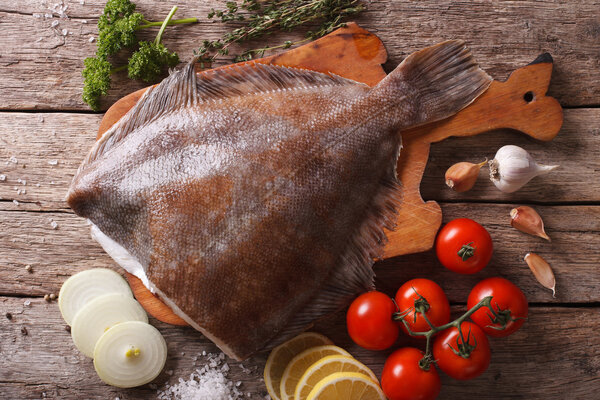 Сырая камбала с ингредиентами на столе крупным планом. Горизонтальный топ
