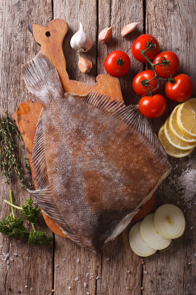 Сырая камбала с ингредиентами на столе крупным планом. вертикальный верх v
