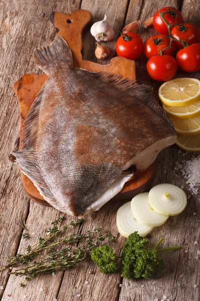 Raw flounder with ingredients on a cutting board close-up. verti — Stock Photo, Image