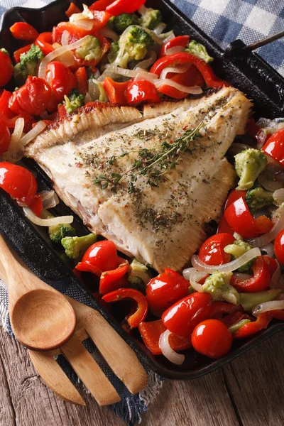 Flatfish with vegetables close-up on a frying pan. vertical — Stock Photo, Image