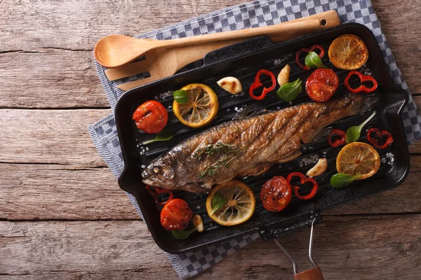 Forelle mit Gemüse auf einer Grillpfanne auf dem Tisch. horizontal zu — Stockfoto