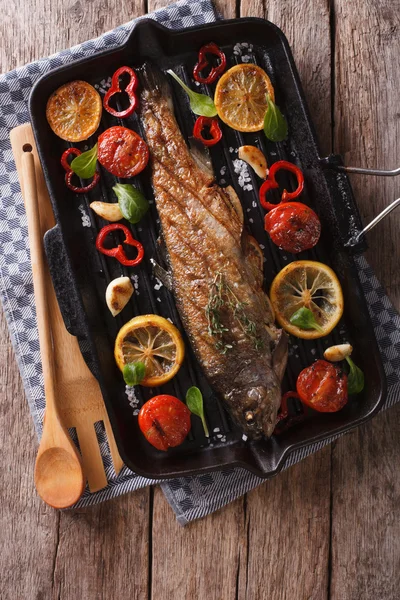 Forelle mit Gemüse auf einer Grillpfanne auf dem Tisch. vertikale Spitze — Stockfoto