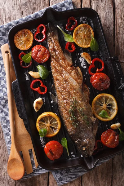 Fischfutter: Forellen in der Grillpfanne aus nächster Nähe. vertikale Ansicht von oben — Stockfoto