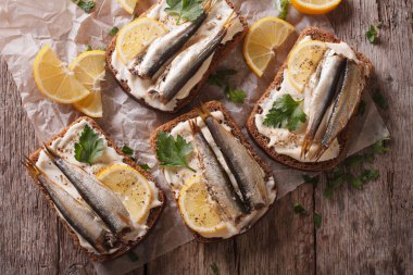 Sandwiches with sprats, cream cheese close-up. Horizontal top vi clipart