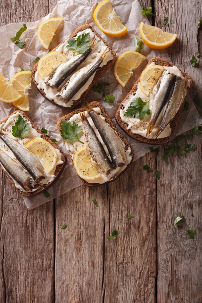 Sandwiches with sprats, cream cheese and lemon. vertical top vie — Stock Photo, Image