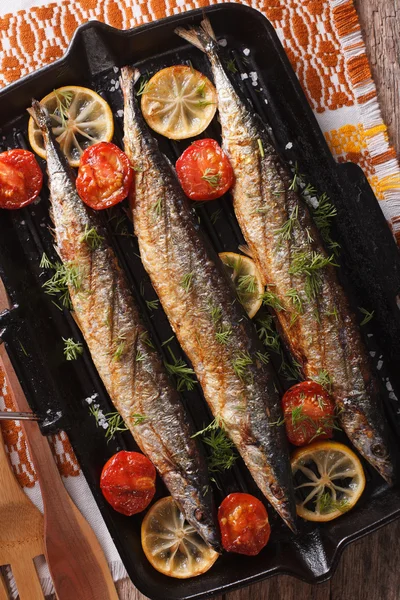 Saury grigliato su una pentola per grill su un primo piano di tavolo. Piano verticale v — Foto Stock