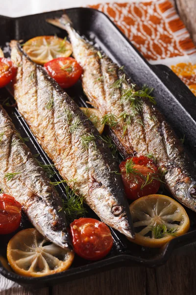 Saury grilled with vegetables on the grill pan closeup. Vertical — Stock Photo, Image