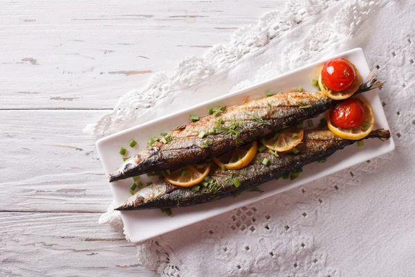 Saury grilled with vegetables on a plate. Horizontal top view — Stock Photo, Image