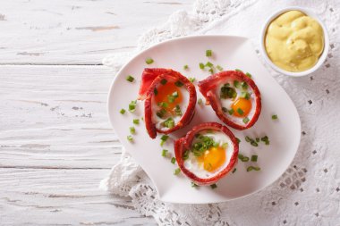 Kızarmış yumurta gevrek domuz pastırması ve sos sarılmış. Yatay üst vie
