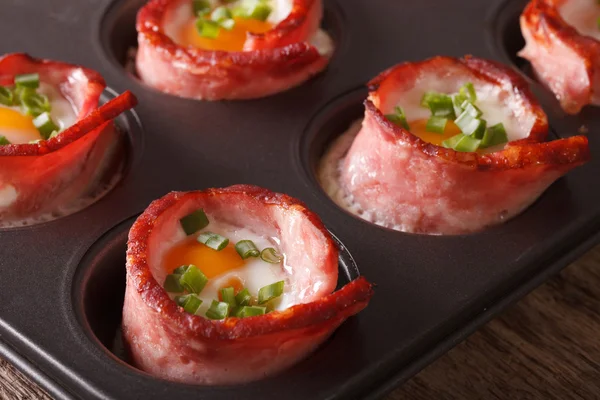 Hot eggs wrapped in bacon close up in baking dish. Horizontal — Stock Photo, Image