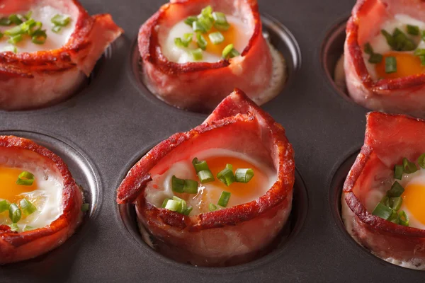 From the oven eggs wrapped in bacon close up in baking dish. Hor — Stock Photo, Image