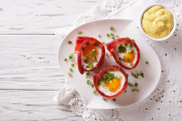 Fried eggs wrapped in crispy bacon and sauce. Horizontal top vie — Stock Photo, Image