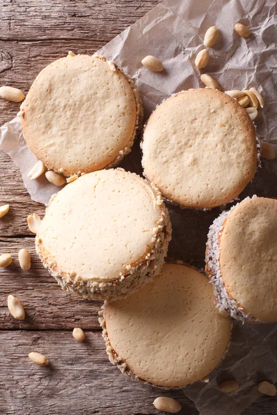 Lekkere koekjes met crème op papier close-up. verticale bovenaanzicht — Stockfoto