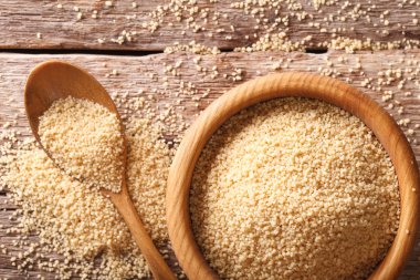 Ahşap kase ve kaşık yakın çekim ham kuskus. Yatay üst