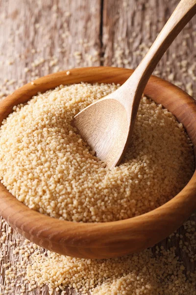 Couscous sec dans un bol en bois gros plan sur la table. Vertical — Photo