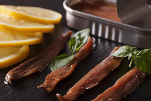 Filets d'anchois et macro citron sur une planche d'ardoise. Horizontal — Photo