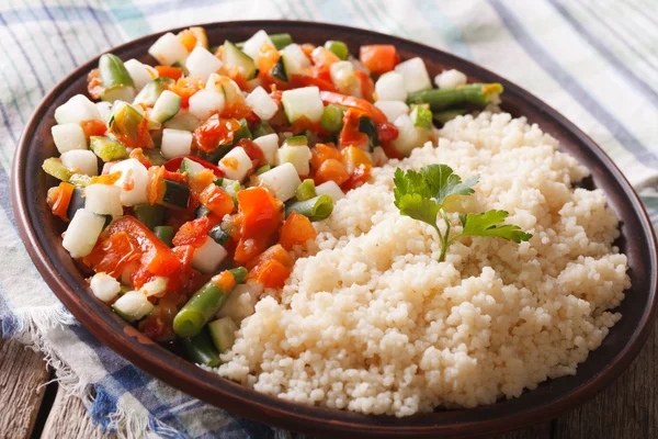 Cuscuz saboroso com salada vegetal close-up em uma chapa. horizonte — Fotografia de Stock