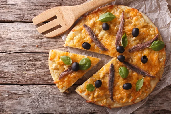 Pizza fatiada com anchovas e cebolas. Vista horizontal superior — Fotografia de Stock