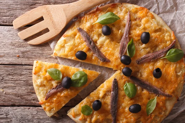 Pizza fatiada com anchovas e cebolas close-up. parte superior horizontal — Fotografia de Stock