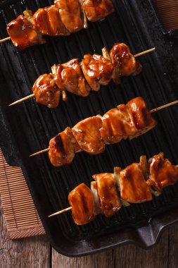 Yakitori şiş tavuk ızgara üzerinde yakın çekim pan. dikey olarak