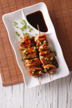 Yakitori tavuk bir plaka üzerinde yeşil soğan ile. Dikey Üstten Görünüm