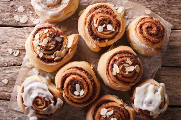 Glazed Cinnamon rolls with almond close up. horizontal top view — Stock Photo, Image