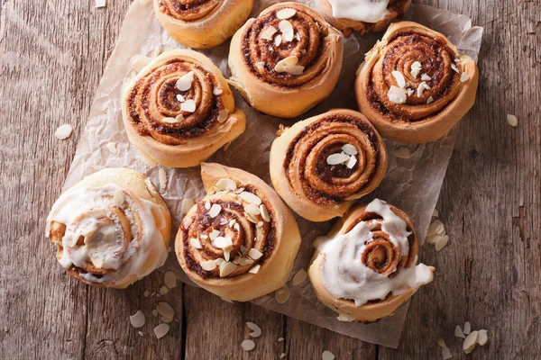 Cinnamon rolls with almond close up on the table. horizontal top — Stock Photo, Image