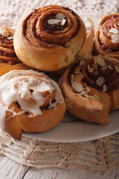 Cinnamon rolls with icing close-up on a plate. Vertical — Stock Photo, Image