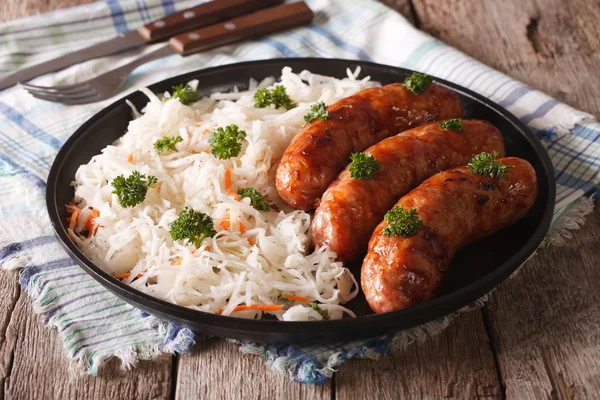 Bratwurst e crauti tedeschi sul tavolo. orizzontale — Foto Stock