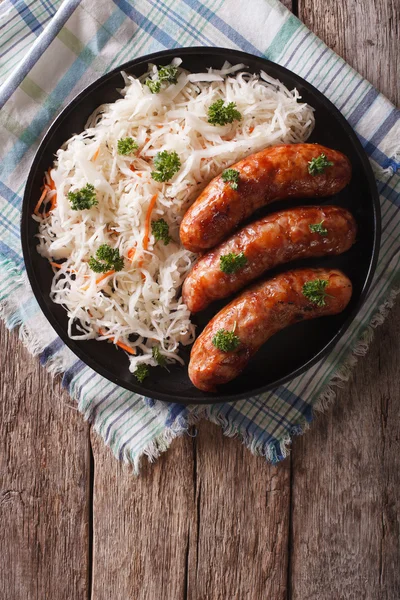 Grilled sausages and sauerkraut on the table. vertical top view — Stock Image Grilled sausages and sauerkraut on the table. vertical top view Stock Photo