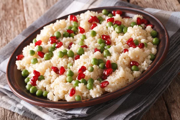 Ensalada de cuscús con guisantes verdes y granada de cerca. horizonte — Foto de Stock