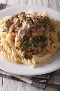 sığır straganof ile bir tabak makarna yakın çekim. Dikey