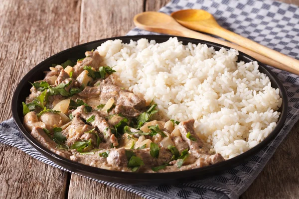 Cozinha russa: stroganoff de carne de vaca com o arroz close-up em um prato . — Fotografia de Stock