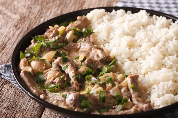 Beef stroganoff garnished with rice close-up on a plate. horizon — Stock Photo, Image