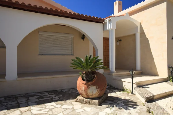 Greek courtyard decorated with clay pitcher and palm tree — Stock Photo, Image