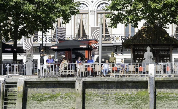 Personnes assises sur la terrasse waterfron — Photo