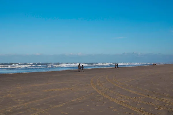 Människor går på stranden i holland — Stockfoto