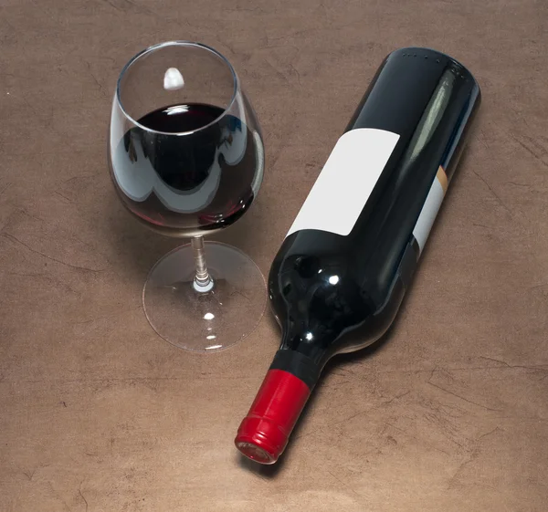 Röd vinflaska och glas — Stockfoto