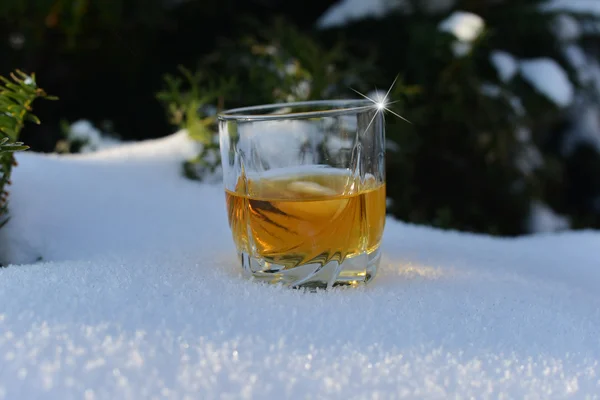 Склянка з холодним віскі в снігу — стокове фото