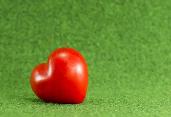 Coração vermelho no fundo grama verde — Fotografia de Stock